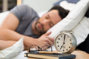 une homme qui dort dans son lit, le sommeil est profond