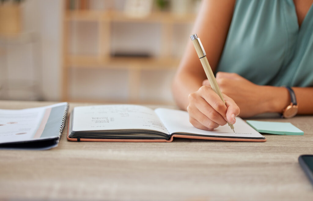 femme qui écrit sur un carnet la technique des petits bonhommes allumettes 